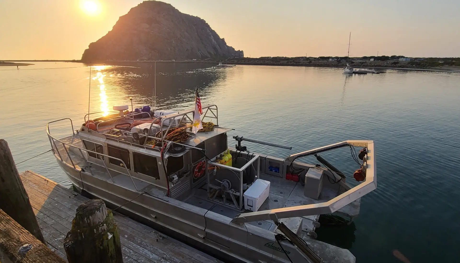 Krull Telecom marine dive support vessel moored at sunset before a shore-end landing